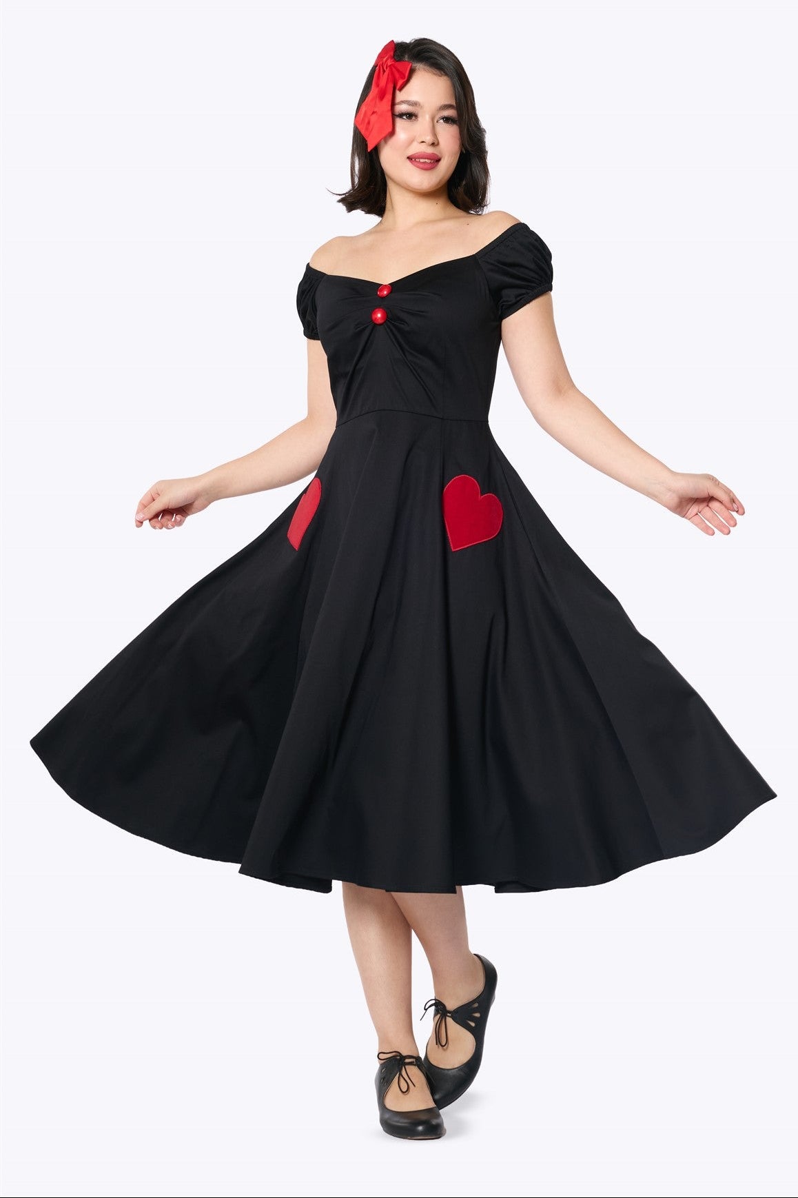 black dress with red hearts Long Wrap star motifs Square neckline Fitted at bodice then gathers from waistline into skirt Maxi length skirt Puff sleeves with frill cuff with ties in self fabric Zip fastening in centre back with large decorative tie Fabric content Red Valentino // Black &