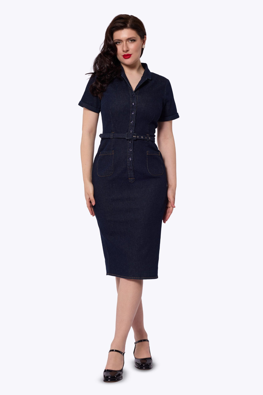 A woman modeling a dark navy blue denim mini dress with short sleeves, a button-up front, and a matching belt, set against a plain white background.